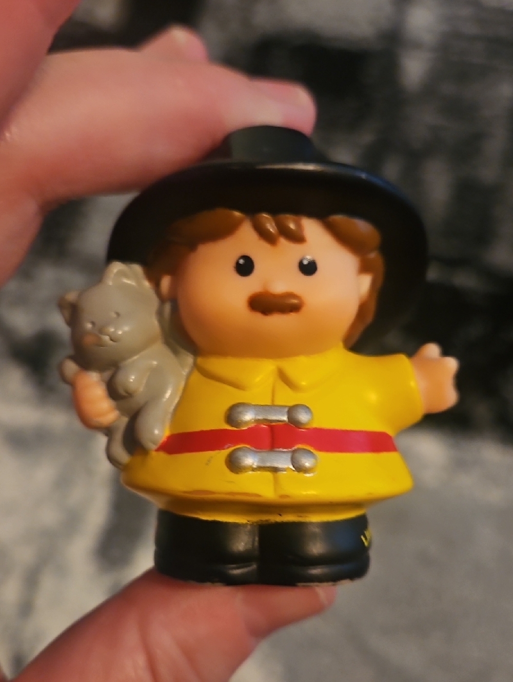 Fisher-Price Little People fireman figure holding a gray cat